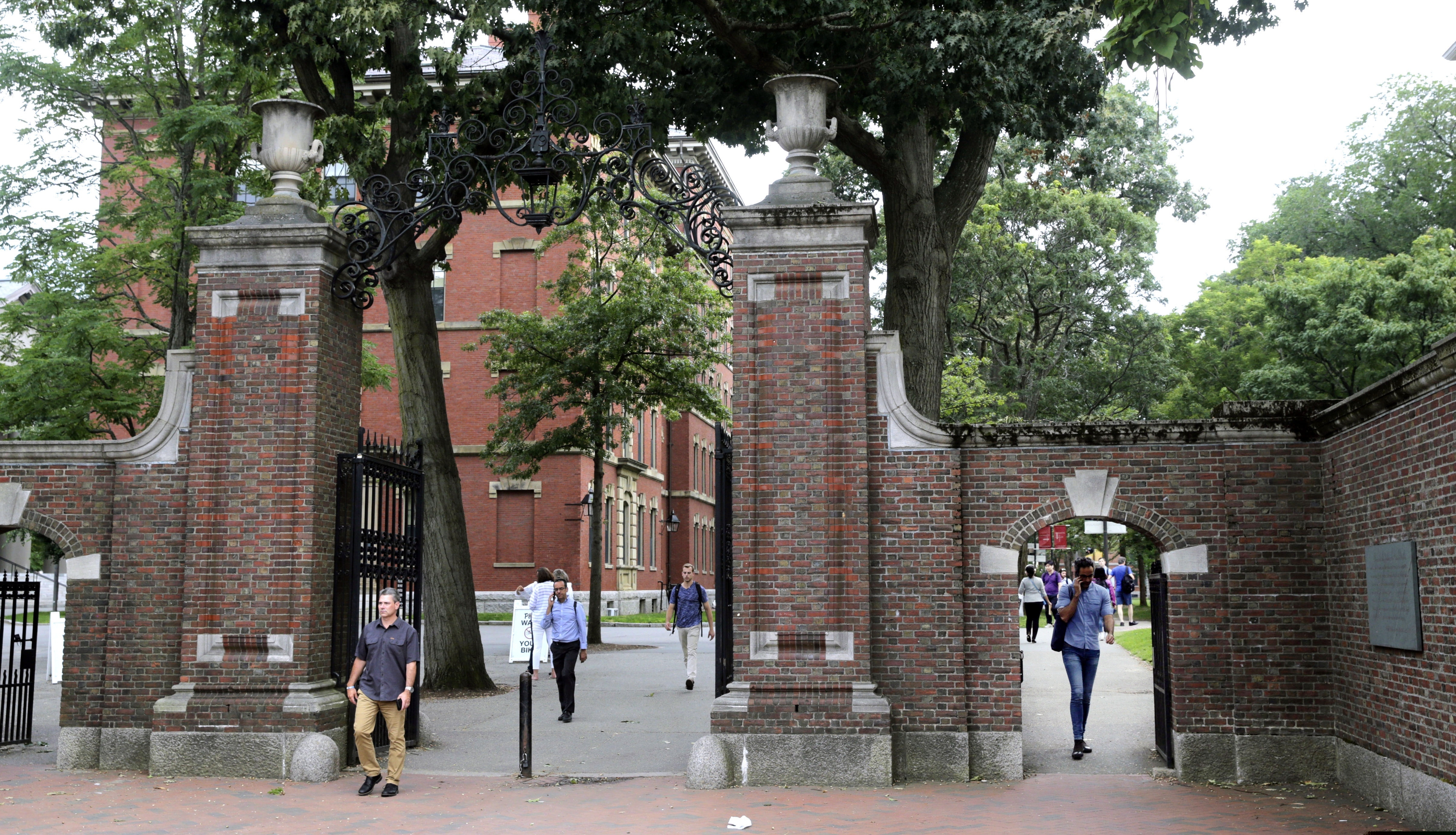 (Charles Krupa | AP file photo) In this Aug. 13, 2019 photo, pedestrians walk through the gates of Harvard Yard at Harvard University in Cambridge, Mass. Harvard and the Massachusetts Institute of Technology filed a federal lawsuit Wednesday, July 8, 2020, challenging the Trump administration's decision to bar international students from staying in the U.S. if they take classes entirely online this fall. Some institutions, including Harvard, have announced that all instruction will be offered remotely in the fall during the ongoing coronavirus pandemic.