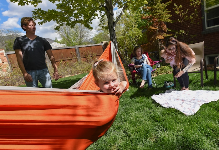 (Francisco Kjolseth | The Salt Lake Tribune) Scott Allen and his wife Rachel are joined by Rachel's mother Jane Danowit as they spend time in their backyard home in Salt Lake on Thursday, May 3, 2018, with their young daughters Audrey, 3, and Cora, 11-weeks. Scott says he wants to raise his kids as free range but his toddler is "constantly trying to kill herself." His wife tends to be a little more vigilant in looking after the kids. As doctors, they're trying to balance a free range childhood with safety practices to prevent their kids experiencing the injuries they witness at work every day. Utah is believed to be the first state to pass a law that prevents parents from being prosecuted for allowing mature kids with good judgement to do things alone, provided they are otherwise cared for.