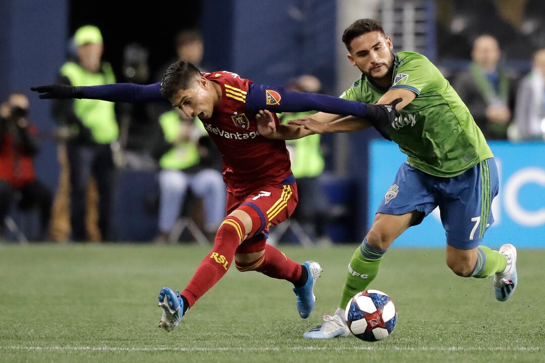 Seattle Sounders midfielder Cristian Roldan, right, fends off Real Salt Lake forward Jefferson Savarino during the first half of an MLS Western Conference semifinal playoff soccer match Wednesday, Oct. 23, 2019, in Seattle. (AP Photo/Ted S. Warren)