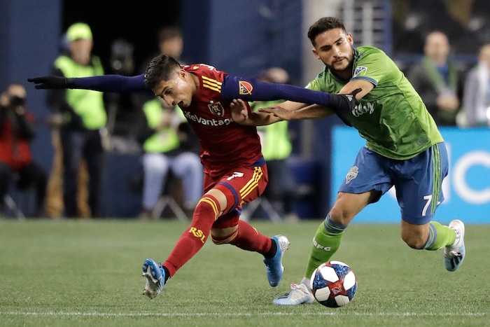 Seattle Sounders midfielder Cristian Roldan, right, fends off Real Salt Lake forward Jefferson Savarino during the first half of an MLS Western Conference semifinal playoff soccer match Wednesday, Oct. 23, 2019, in Seattle. (AP Photo/Ted S. Warren)