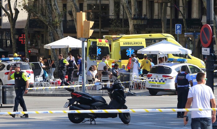 Injured people are treated in Barcelona, Spain, Thursday, Aug. 17, 2017 after a white van jumped the sidewalk in the historic Las Ramblas district, crashing into a summer crowd of residents and tourists and injuring several people, police said. (AP Photo/Oriol Duran)