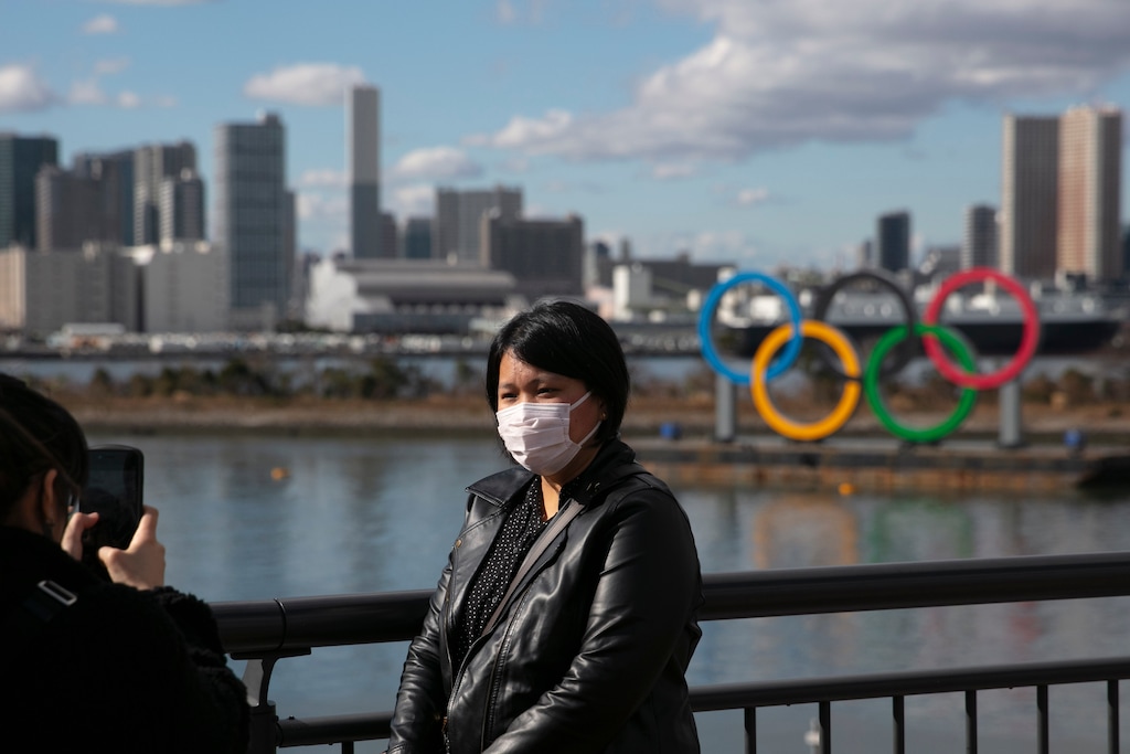 (Jae C. Hong | AP) A tourist wearing a mask poses for a photo with the Olympic rings in the background, at Tokyo's Odaiba district, Jan. 29, 2020. A top Olympic official made clear Friday the 2020 Games in Tokyo will not be canceled despite the virus that has spread from China.