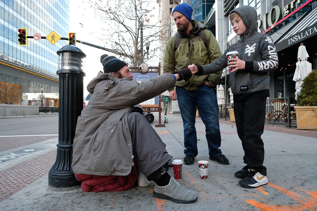 (Francisco Kjolseth  |  The Salt Lake Tribune) Ten-year-old Chase Hansen and his father John who have an organization called Project Empathy, meet Chris Coons in downtown Salt Lake City on Monday, Dec. 16, 2019, after bringing him a coffee and finding out about his life and what he needs. The two of them spend time with people experiencing homelessness in an effort to connect with people on a personal level. On this occasion Chase learns that Coons used to be an electrician before losing much of his vision and how he loved to ski.