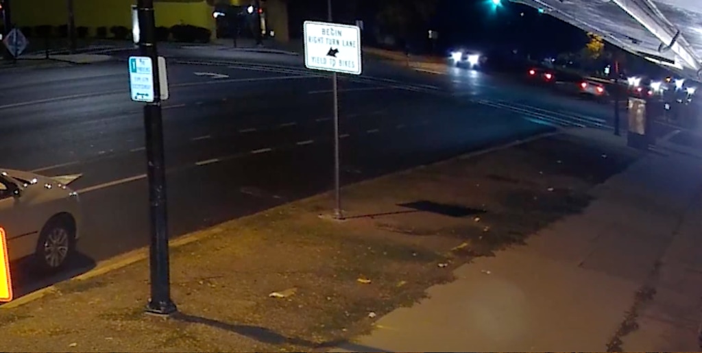 (Screenshot) Screenshot from a video taken seconds before a Weber State University officer hits a pedestrian with his squad car on Sept. 30, 2021. The video was captured by a nearby business. The officer is in the car in the center of the frame where there are headlights shining on the intersection.