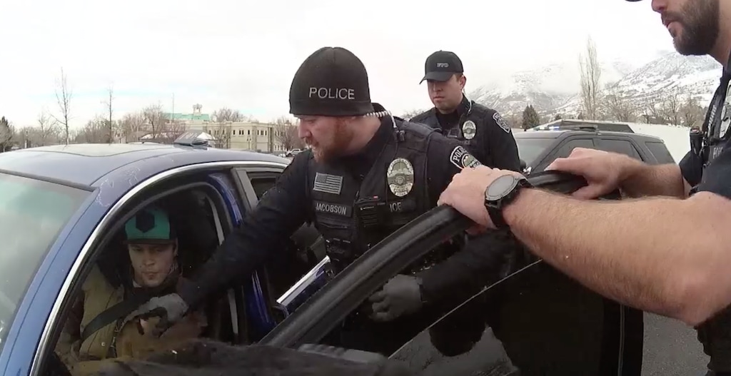 (Farmington Police Department) In a screenshot taken from a body camera footage presentation, law enforcement officers attempt to remove Chase Allan from his vehicle during a traffic stop on March 1, 2023.