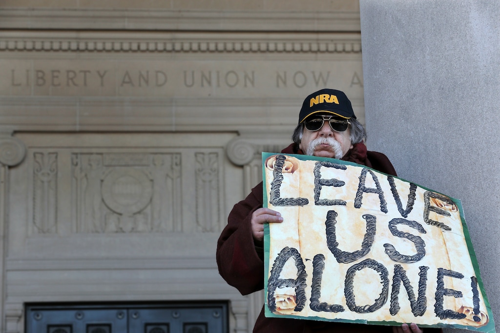 (Mel Evans | The Associated Press) A man holds a sign as he stands outside the War Memorial, near a group of Second Amendment advocates gathered in opposition to about a half-dozen gun control bills expected to get a vote in the Assembly on Monday, March 26, 2018, near the Statehouse in Trenton, N.J.