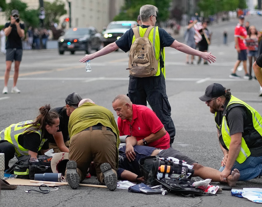 (Francisco Kjolseth | The Salt Lake Tribune) Medical personnel attend to an injured man after a reported shooting during a demonstration in downtown Salt Lake City on Saturday, June 14, 2025.