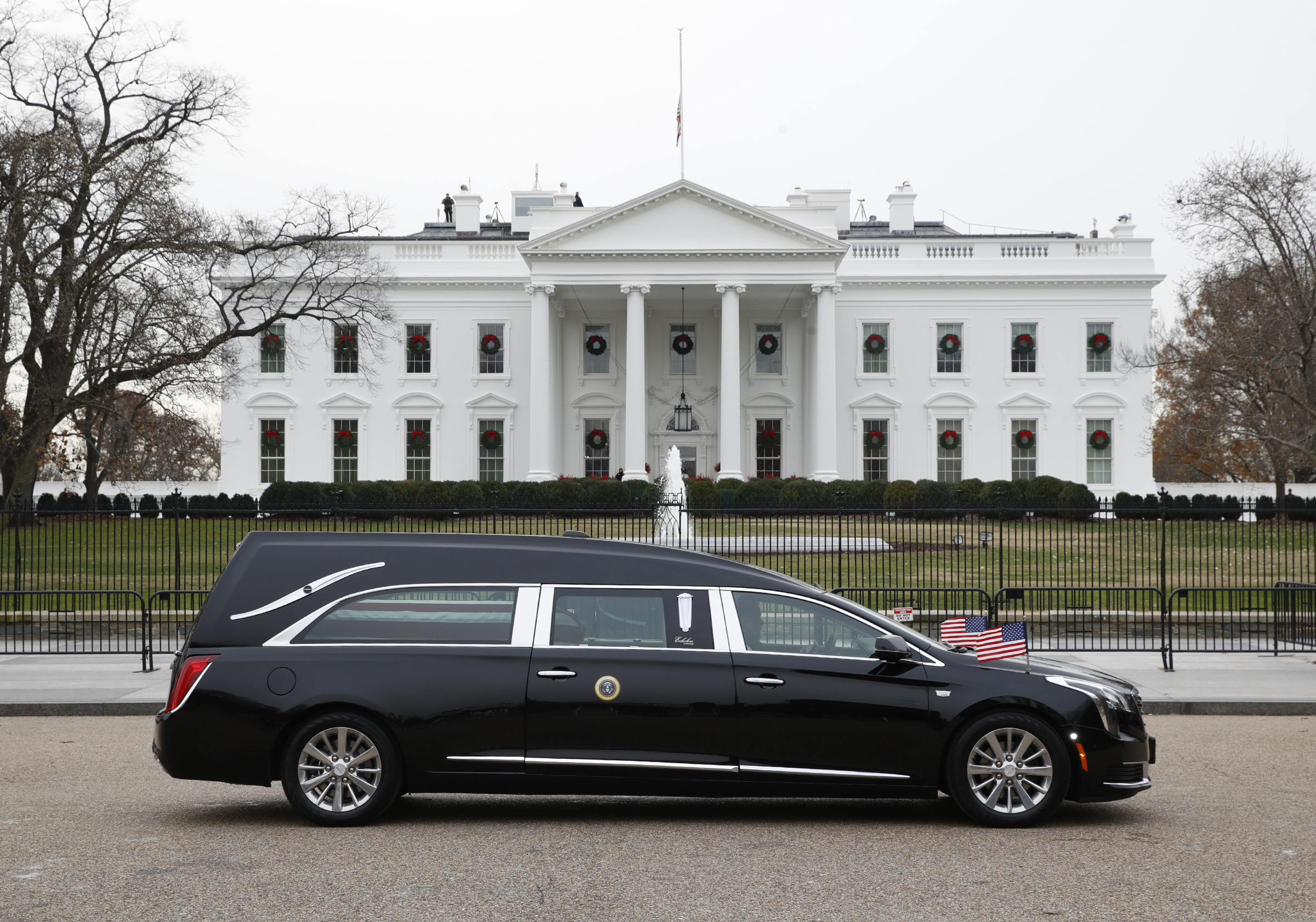 The hearse carrying the flag-draped casket of former President George H.W. Bush passes by the White House from the Capitol, heading to a State Funeral at the National Cathedral, Wednesday, Dec. 5, 2018, in Washington. AP Photo/Jacquelyn Martin).
