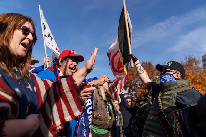 Trump supporters, at left, demonstrating the election results are confronted by counter protestors at the State Capitol in Lansing, Mich., Saturday, Nov. 7, 2020.  Democrat Joe Biden defeated President Donald Trump to become the 46th president of the United States on Saturday, positioning himself to lead a nation gripped by the historic pandemic and a confluence of economic and social turmoil.(AP Photo/David Goldman)