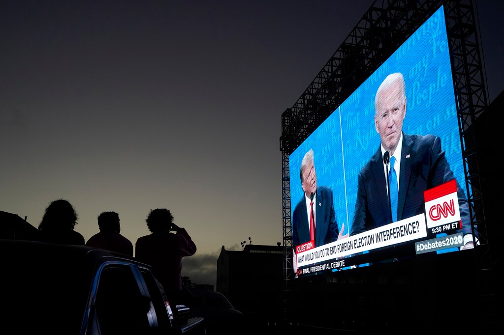 (Jeff Chiu | AP photo)
People watch from their vehicle as President Donald Trump, on left of video screen, and Democratic presidential candidate former Vice President Joe Biden speak during a Presidential Debate Watch Party at Fort Mason Center in San Francisco, Thursday, Oct. 22, 2020. The debate party was organized by Manny's, a San Francisco community meeting and learning place.