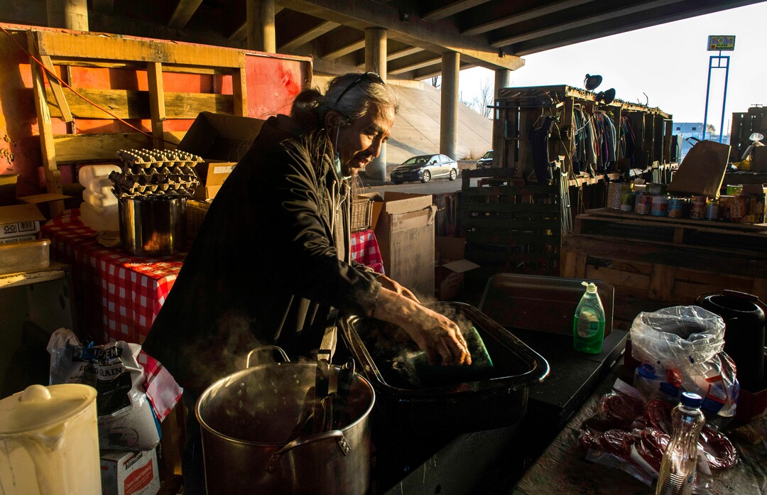 (Rick Egan | The Salt Lake Tribune) Dave John, a volunteer with the nonprofit group PANDOS, scrubs the pots and pans he used to cook breakfast, so he can use them to cook dinner at Camp Last Hope on Saturday, Jan. 2, 2021. John cooks meals each Saturday and Sunday for the unsheltered at Last Hope, and anyone else experiencing hunger that might need food.