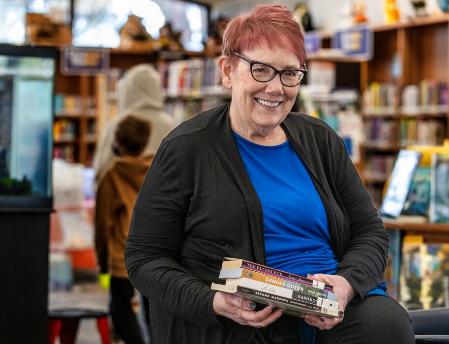 (Leah Hogsten | The Salt Lake Tribune) Salt Lake County Library System Librarian Wanda Mae Huffaker holds four of nine books that have been removed from schools in the Canyons School District and placed under review, Nov. 23, 2021. 