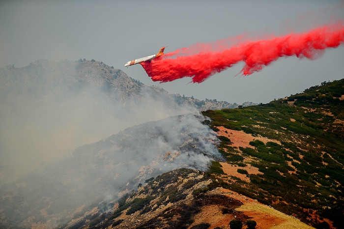 (Trent Nelson | The Salt Lake Tribune)  A plane makes a drop on a fire at the mouth of Weber Canyon, Tuesday September 5, 2017.