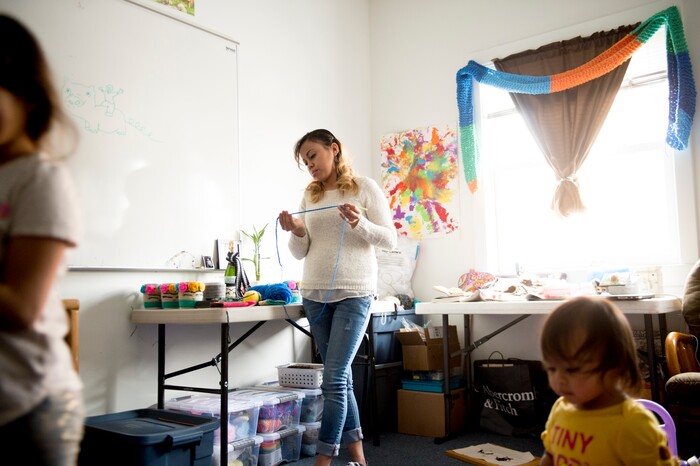 (Jeremy Harmon  |  The Salt Lake Tribune) Vicky Chavez inspects a piece of yarn as her daughters play in their room at the First Unitarian Church on 1300 East in Salt Lake City on Dec. 14, 2018. Chavez makes a little bit of extra money by crocheting items for friends and family.