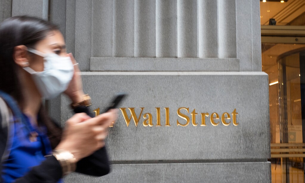 (Mark Lennihan | AP photo)

In this June 30 photo, a woman wearing a mask passes a sign for Wall Street during the coronavirus pandemic.