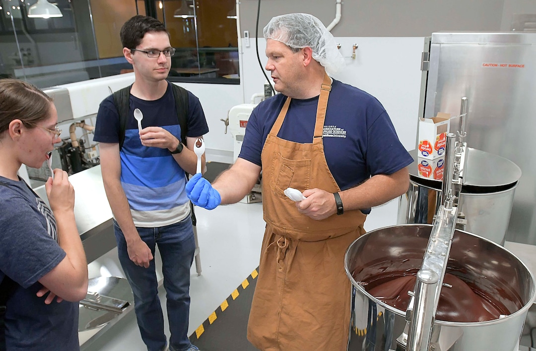 (Eli Lucero  |  The Herald Journal) Steve Shelton, right, talks to Akyra Winsor and Cameron Winsor while handing out samples during a public tour of the Aggie Chocolate Factory on Tuesday in Logan.