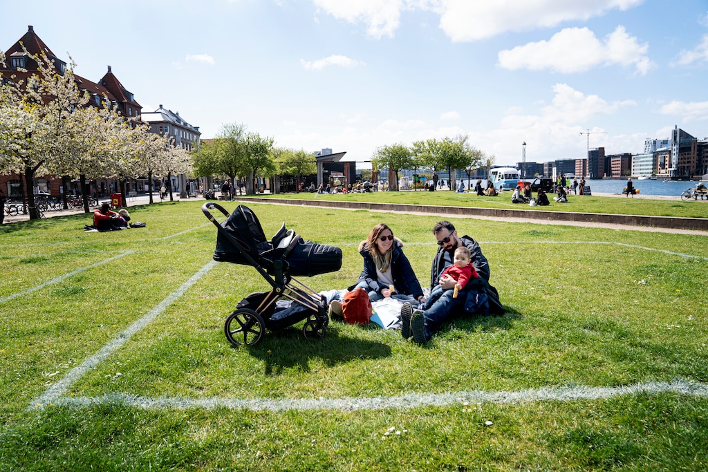 (Ida Guldbaek Arentsen | Scanpix via AP) Marina and Andrea enjoy the sun with their daughter Sara at Islands Brygge in Copenhagen on Sunday, May 3, 2020. Marked areas on the grassland help people keep distance from each other, with about 40 m2 area marked out for a maximum of 10 people, to limit the spread of coronavirus infection, seen with 24 mm telephoto lens.
