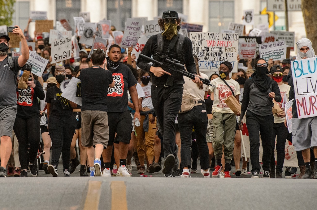 (Trent Nelson  |  The Salt Lake Tribune) A protester since identified as Arturo Gamboa carries an AR-15 style rifle near the Utah Capitol during a march against police brutality in Salt Lake City on Saturday, Aug. 22, 2020.
