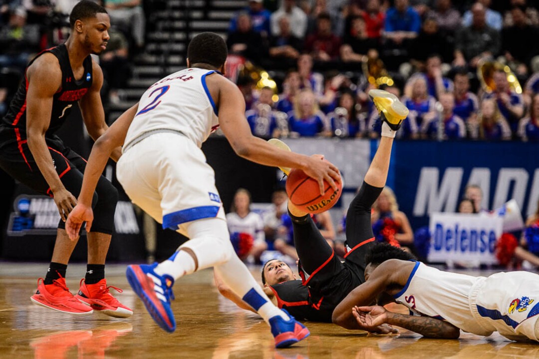 (Trent Nelson | The Salt Lake Tribune)  Kansas Jayhawks guard Charlie Moore (2) picks up a turnover as Kansas faces Northeastern in the 2019 NCAA Tournament in Salt Lake City on Thursday March 21, 2019.