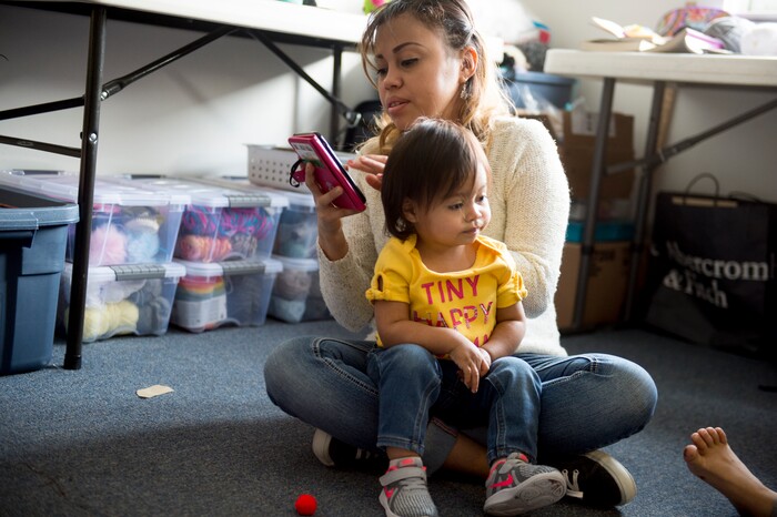 (Jeremy Harmon  |  The Salt Lake Tribune) Vicky Chavez replies to a text from a family member as she looks after her daughters, 17-month-old Bella and 7-year-old Yaretzi, in their room at the First Unitarian Church on 1300 East in Salt Lake City on Dec. 14, 2018.
