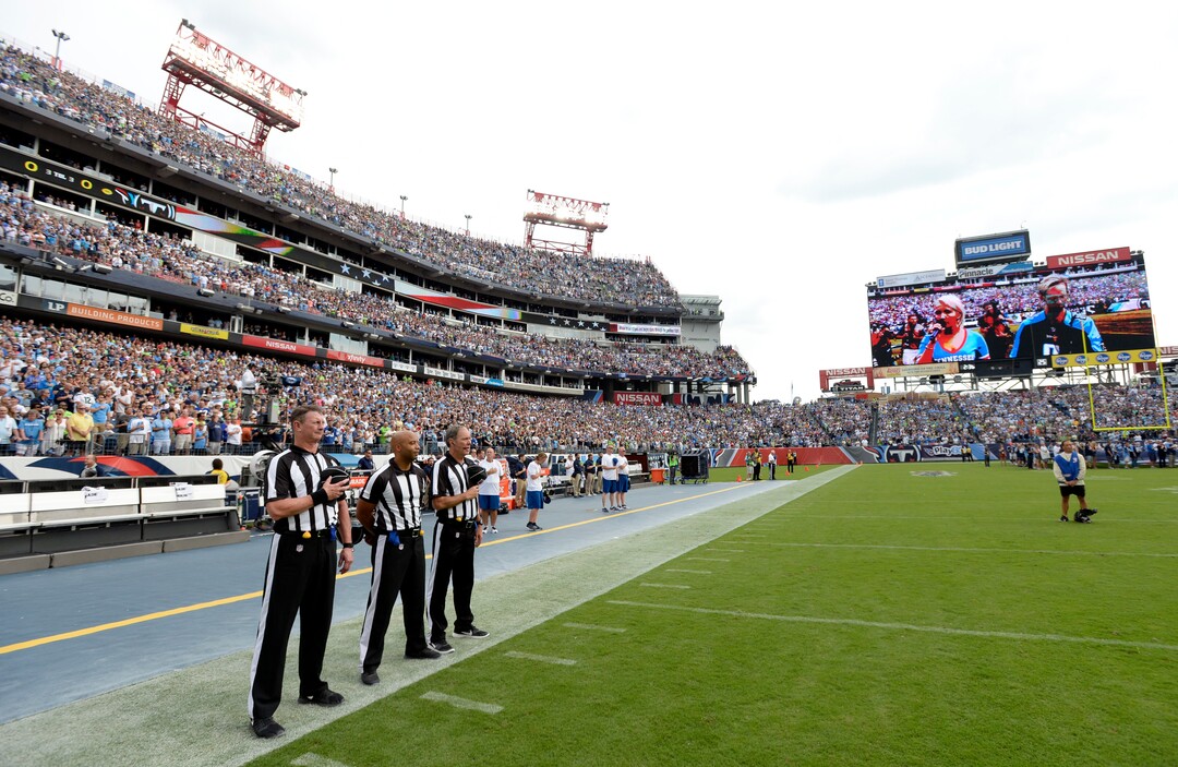 Officials stand on the sideline of the Seattle Seahawks during the playing of the national anthem before an NFL football game between the Seahawks and the Tennessee Titans Sunday, Sept. 24, 2017, in Nashville, Tenn. Neither team came out onto the field for the anthem. (AP Photo/Mark Zaleski)