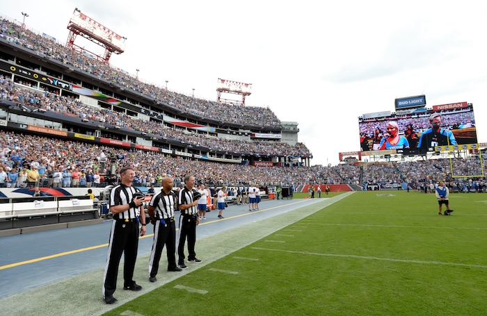 Officials stand on the sideline of the Seattle Seahawks during the playing of the national anthem before an NFL football game between the Seahawks and the Tennessee Titans Sunday, Sept. 24, 2017, in Nashville, Tenn. Neither team came out onto the field for the anthem. (AP Photo/Mark Zaleski)