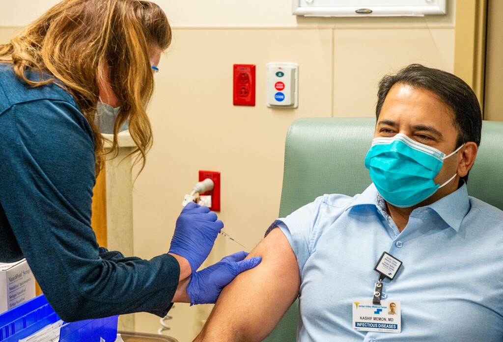 (Rick Egan | The Salt Lake Tribune) Infections disease physician Kashif Memon, gets a covid-19 vaccine from Melissa Clayton, Inpatient Director, as Lehi's Mountain Point Medical Center gives out its first COVID-19 vaccines on Thursday, Dec. 17, 2020.