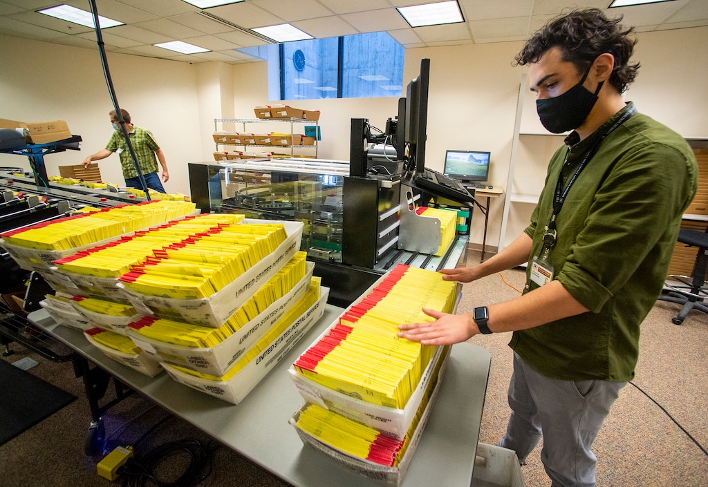 (Rick Egan  |  Tribune file photo)   Carson Adams prepares primary election ballots for counting at the Salt Lake County Government Center on July 1, 2020. The League of Women Voters of Utah is coming out in opposition to Amendment G on the November ballot, saying it would be bad for public schools.