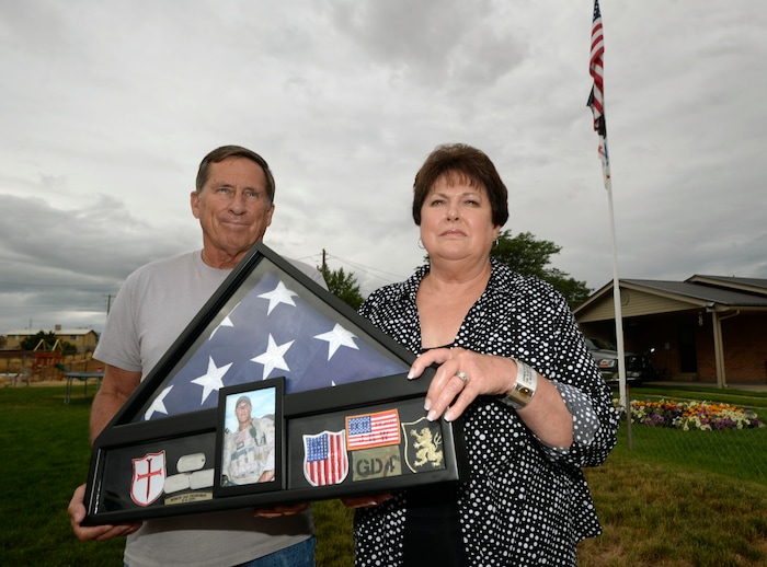 Al Hartmann  |  The Salt Lake Tribune 
Betty and Rodney Workman of Blanding hold a case of dog tags, Marine patches and the American flag that honored their son Jason who was buried with honors at Arlington Cemetery.  Jason Workman, a member of Seal Team 6 was among 38 military personnel shot down by Taliban fighters in a Chinook helicopter on Aug. 6, 2011. It was the largest loss of U.S. life in the Afghanistan campaign.  Two Utahns were on the helicopter,  Taylorsville's Jared Day and Blanding's Jason Workman. Five years later, family and friends still grapple with their absence while battling to keep alive their memory — Workman, as a big, daring family man with a kind heart and Day as a "goofball" who loved video games and anime and who could make people laugh during times of extreme stress.
The two men shared a birthday, Aug. 12.  
