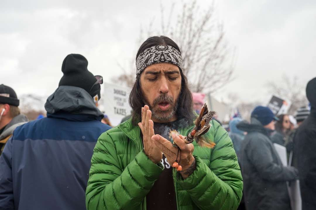 (Rachel Molenda  |  The Salt Lake Tribune)  Daniel Tucson, of Salt Lake City, burns sage and prays at a protest against shrinking Bears Ears and Grand Staircase Escalante national monuments on Monday, December 4, 2017.