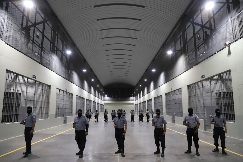 FILE - Prison guards stand outside holding cells at the Terrorism Confinement Center, a "mega-prison" built especially for gang members, during a media tour in Tecoluca, El Salvador, Feb. 2, 2023. Utah attorneys say a Venezuelan man was detained in San Diego and transported to the Salvadoran prison, where they allege he was tortured. (AP Photo/Salvador Melendez, File)