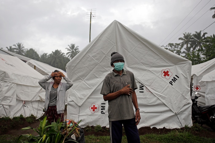(Firdia Lisnawati | The Associated Press) Villagers stand in front of their makeshift tents at an evacuated area in Karangasem, Indonesia, Monday, Nov. 27, 2017. Indonesian authorities ordered a mass evacuation of people Monday from an expanded danger zone around an erupting volcano on Bali that has forced the island’s international airport to close, stranding tens of thousands of travelers.