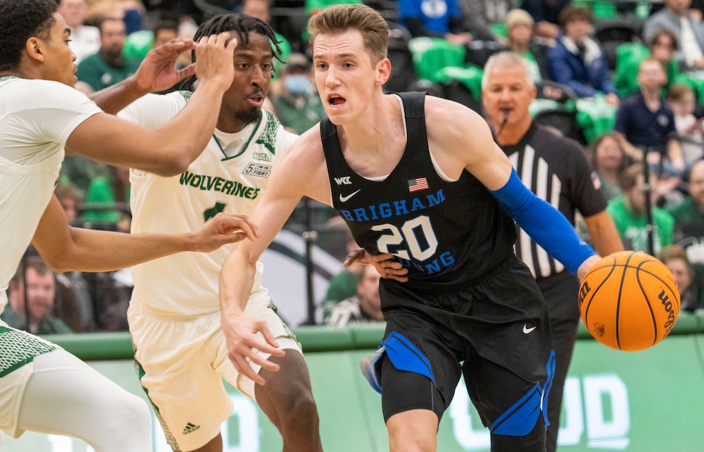 (Rick Egan | The Salt Lake Tribune) Brigham Young Cougars guard Spencer Johnson (20) takes the ball up the middle as Utah Valley Wolverines guard Le'Tre Darthard (1) defends, in basketball action between the Brigham Young Cougars and the Utah Valley Wolverines in Orem, on Wednesday, Dec. 1, 2021.