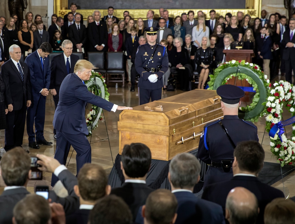 (AP Photo/J. Scott Applewhite) President Donald Trump touches the casket of Rev. Billy Graham, who died last week at age 99, during a ceremony in the Capitol Rotunda where he will lie in honor as a tribute to America's most famous evangelist, Wednesday, Feb. 28, 2018, in Washington. He is joined from left by Vice President Mike Pence, Speaker of the House Paul Ryan, R-Wis., and Senate Majority Leader Mitch McConnell, R-Ky.