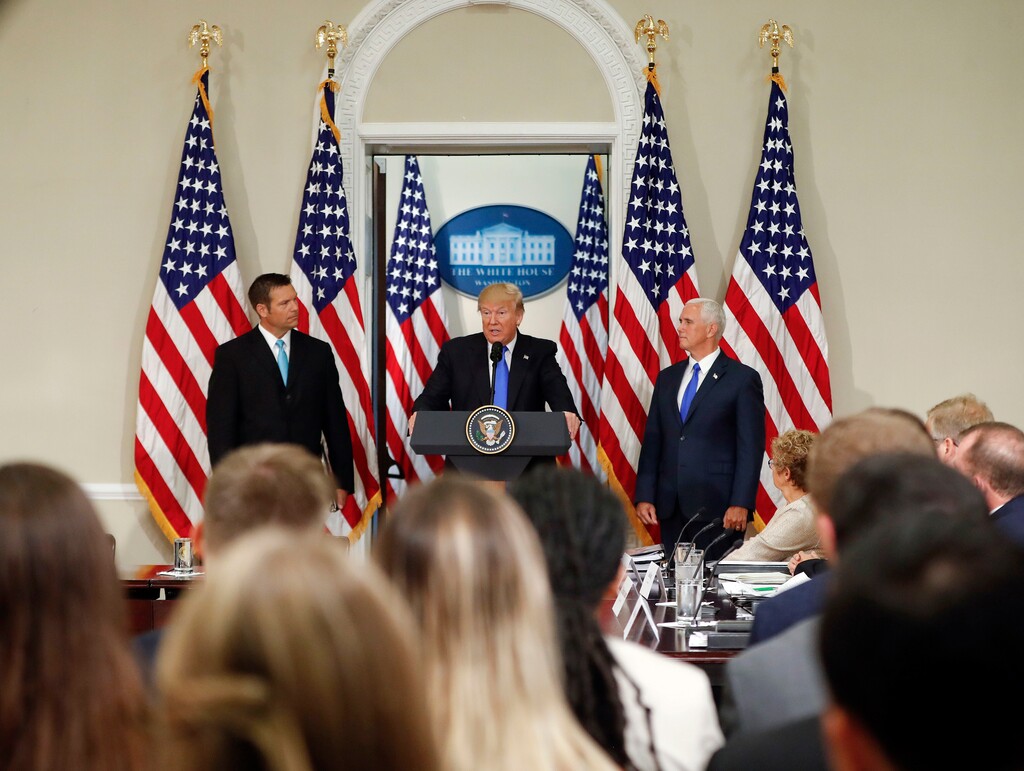 FILE - In this July 19, 2017, file photo, President Donald Trump, with Kansas Secretary of State Kris Kobach, left, and Vice President Mike Pence, right, speaks at a meeting of the Presidential Advisory Commission on Election Integrity in the Eisenhower Executive Office Building on the White House complex in Washington. Trump’s campaign to discredit the news media has spread to state and local officials, who are echoing his use of the term “fake news” as a weapon against unflattering stories and information that can tarnish their images. (AP Photo/Pablo Martinez Monsivais, File)