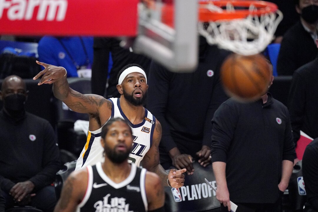 Utah Jazz forward Royce O'Neale, top, makes a three-point shot as Los Angeles Clippers guard Paul George watches during the first half in Game 6 of a second-round NBA basketball playoff series Friday, June 18, 2021, in Los Angeles. (AP Photo/Mark J. Terrill)