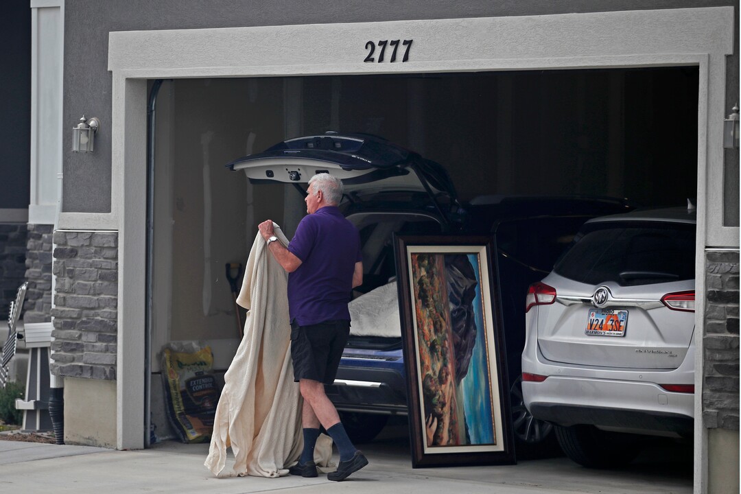 (George Frey  |  for The Salt Lake Tribune) A man loads his cars with paintings in case he is ordered to evacuate from his home in south Saratoga Springs due to a wildfire on June 28, 2020.
