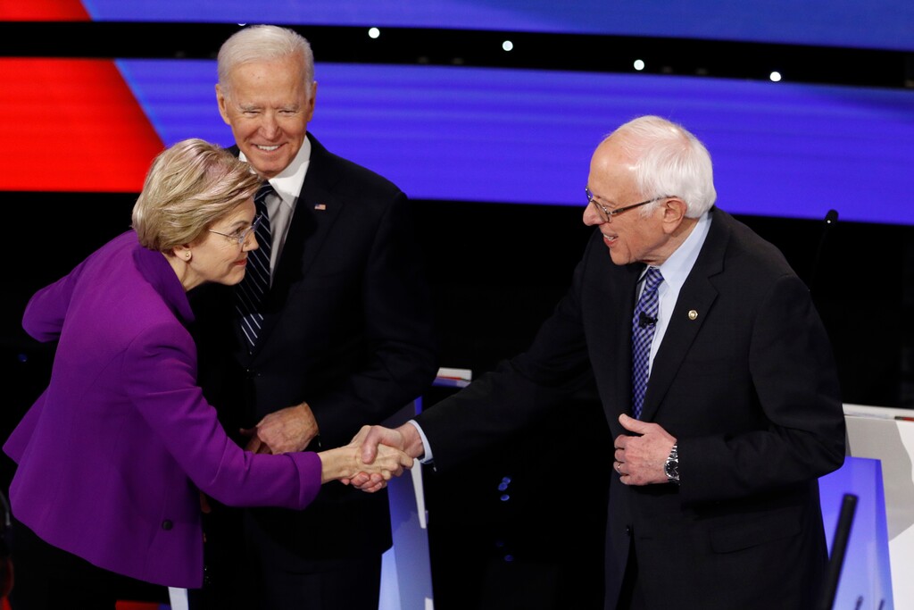 (Patrick Semansky | The Associated Press)
Democratic presidential candidates Sen. Elizabeth Warren, D-Mass., left, and Sen. Bernie Sanders, I-Vt., right greet each other as former Vice President Joe Biden, watches Tuesday, Jan. 14, 2020, before a Democratic presidential primary debate hosted by CNN and the Des Moines Register in Des Moines, Iowa.