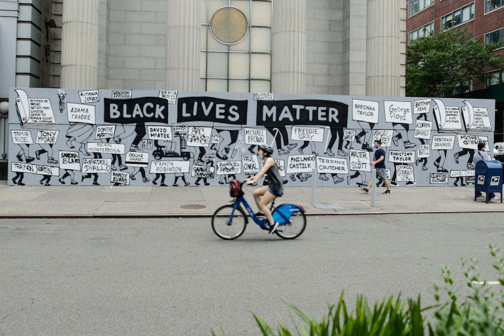 (Frank Franklin II | AP) Pedestrians and a cyclist pass a mural in Union Square calling for justice over the death of George Floyd, and to highlight police brutality nationwide, Thursday, June 11, 2020, in New York. Floyd, a black man, died after he was restrained by Minneapolis police on May 25.