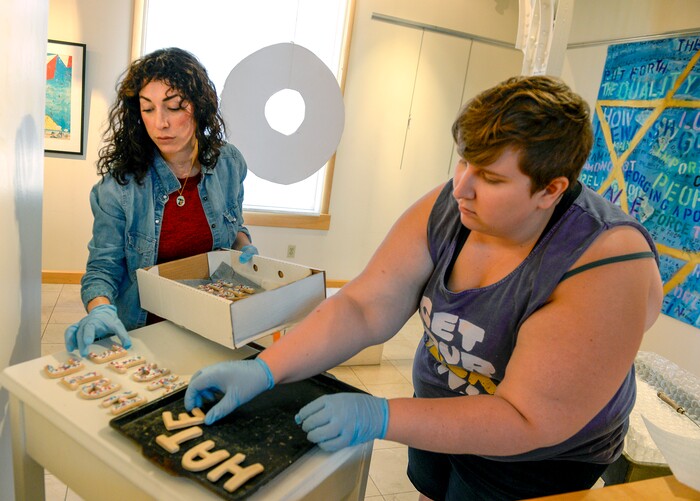 Leah Hogsten  |  The Salt Lake Tribune l-r Jennifer Ortiz and Maggie Sherwood arrange "hate" cookies Tuesday, June 12, 2018 from the work of mixed media artist Miguel Guillen titled "The Cooling Table," at the exhibit, "Speaking Volumes: Transforming Hate," opening Friday, June 15 at the Ogden Union Station Museum. The exhibit showcases 30 artists who transformed white-supremacist books into uplifting works of art.