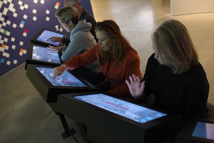 (Francisco Kjolseth  |  The Salt Lake Tribune)  Kimberly Labertew, center, and Kathy DeDemple, at right, both of Park City, try out a new interactive game at the Natural History Museum of Utah at the Rio Tinto Center. The new multiplayer game called Utah Climate Challenge is devised to help visitors consider issues of sustainability, biodiversity, population growth and urban sprawl. Located in the Utah Futures Gallery, the game is designed by Preloaded, a London-based company that specializes in designing games with a purpose to tackle complicated issues for a general audience.