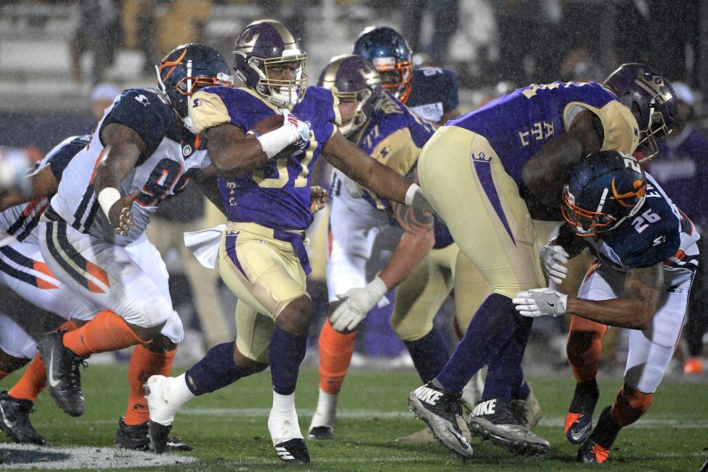 Atlanta Legends running back Lawrence Pittman rushes in front of Orlando Apollos defensive end Anthony Moten Jr. (98) during the second half of an Alliance of American Football game Saturday, Feb. 9, 2019, in Orlando, Fla. (AP Photo/Phelan M. Ebenhack)