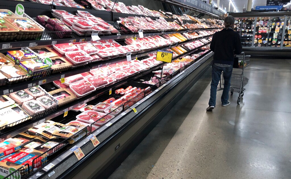 FILE - In this May 10, 2020 file photo, a shopper pushes his cart past a display of packaged meat in a grocery store. (AP Photo/David Zalubowski, File)