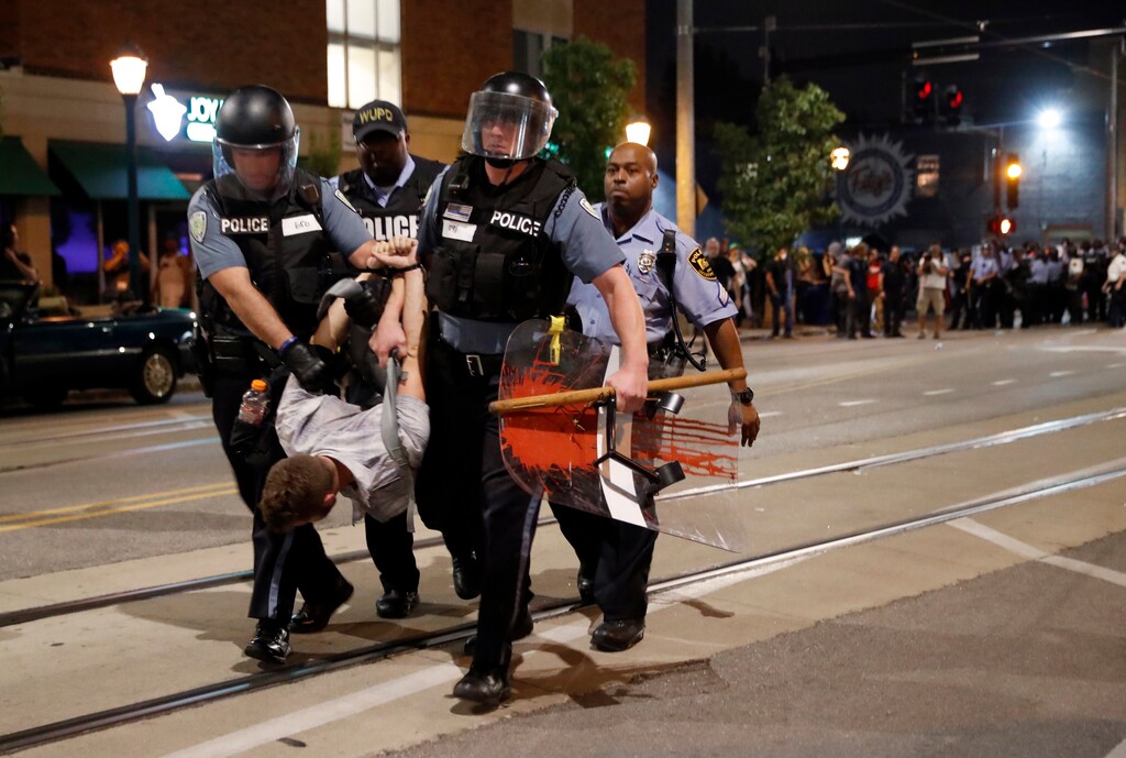 (Jeff Roberson | The Associated Press) Police arrest a man as they try to clear a violent crowd Saturday, Sept. 16, 2017, in University City, Mo. Earlier, protesters marched peacefully in response to a not guilty verdict in the trial of former St. Louis police officer Jason Stockley.