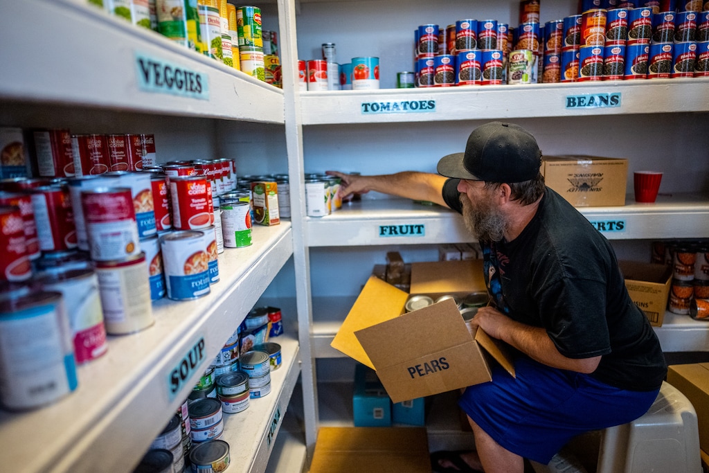 (Trent Nelson  |  The Salt Lake Tribune) Isaac McDonald stocks shelves in the food pantry at Crossroads Urban Center in Salt Lake City on Wednesday, June 29, 2022.