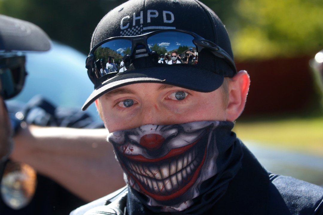A Cottonwood Heights police officer speaks with protesters during a march Sunday, Aug. 2, 2020, in Cottonwood Heights, Utah. The protest was a "March for Justice" focused largely around Zane James, who was fatally shot by police in Cottonwood Heights in 2018. (AP Photo/Rick Bowmer)