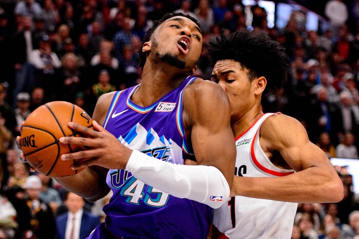 (Trent Nelson  |  The Salt Lake Tribune) Utah Jazz guard Donovan Mitchell (45) is fouled by Portland Trail Blazers guard Anfernee Simons (1) in the fourth quarter as the Utah Jazz host the Portland Trail Blazers, NBA basketball in Salt Lake City on Thursday, Dec. 26, 2019.