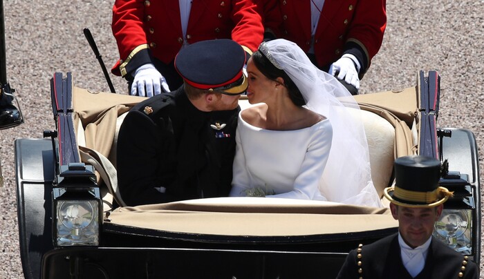 Britain's Prince Harry and Meghan Markle kiss as they ride in a carriage down the Long Walk after their wedding ceremony of Prince Harry and Meghan Markle at St. George's Chapel in Windsor Castle in Windsor, near London, England, Saturday, May 19, 2018. (Yui Mok/pool photo via AP)