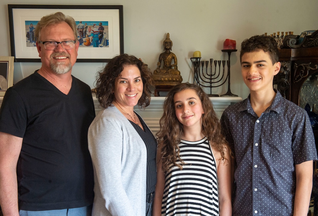 (Rick Egan  |  The Salt Lake Tribune)    Stephen Washburn, April Washburn, Zoe Dobiner, and Aiden Dobiner, next to religious symbols in their home.  Stephen and April Washburn are an interfaith couple. He is Episcopalian; she's Jewish. Thursday, April 18, 2019.