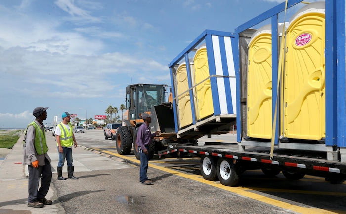 (Jennifer Reynolds | The Galveston County Daily News) A Galveston Park Board of Trustees crew removes portable toilets from the seawall Thursday, Aug. 24, 2017, as they prepare the beachfront for severe weather from Hurricane Harvey in Galveston, Texas.  The National Hurricane Center is forecasting Harvey will become a major hurricane to hit the middle Texas coastline.